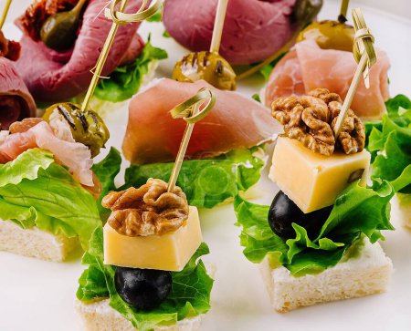 Foto de Elegante surtido de canapés con queso, frutos secos y carnes curadas, perfectos para catering y eventos - Imagen libre de derechos