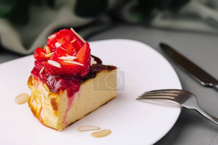 Delectable slice of strawberry cheesecake garnished with fresh berries and almond flakes, served on a white plate