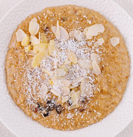 Top view of a healthy bowl of almond and coconut porridge close up