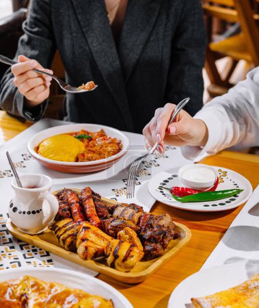 Deux personnes partageant un repas copieux avec plusieurs plats à une table à manger confortable