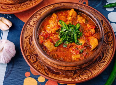 Three savory stew dishes in clay pots, garnished with fresh herbs on a colorful tablecloth