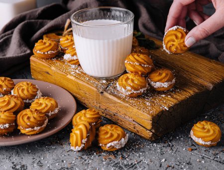 Delectable viennese whirls on a rustic wooden board with a glass of milk