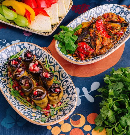 Lebendige Gerichte einer mediterranen Mahlzeit auf einer dekorativen Tischdecke ausgebreitet
