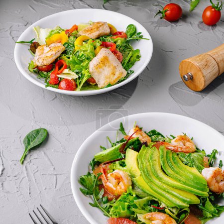 Photo for Two bowls of vibrant shrimp avocado salad, perfect for healthy eating, on a gray textured background - Royalty Free Image