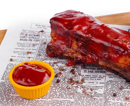 Juicy barbecued pork ribs with a glossy sauce, served with potato wedges and a side of dip