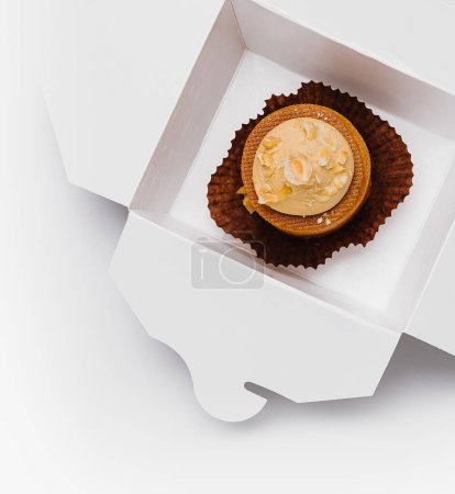Foto de Solo cupcake decadente con glaseado se encuentra dentro de una elegante caja blanca abierta - Imagen libre de derechos