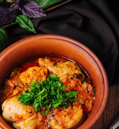 Traditional chicken stew with herbs and vegetables served in a rustic ceramic bowl, perfect for a comforting meal