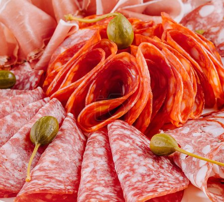 Tantalizing selection of cured meats garnished with capers close up