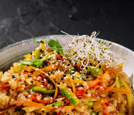 Tazón de arroz vibrante con verduras frescas y sésamo, servido en un plato elegante sobre un fondo oscuro