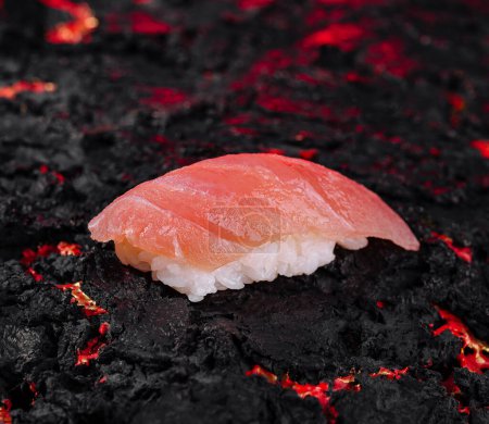 A single sushi piece on a lava rock, symbolizing heat and freshness