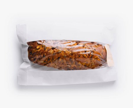 Top view of a rustic, crusty loaf of bread wrapped in a paper bag on a white background