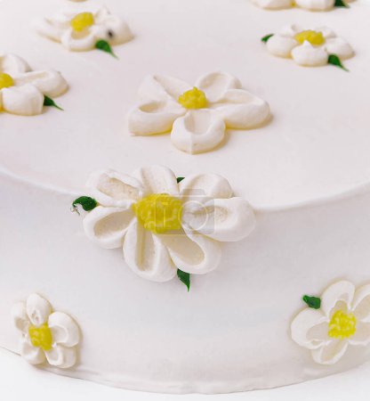 Exquisite und elegante weiße Gänseblümchen-Torte mit handgemachten Fondant-Zuckerblumen. Perfekt für eine Geburtstags- oder Hochzeitsfeier. Ein köstliches Meisterwerk des Feinschmeckergebäcks