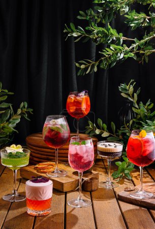 Diverse collection of crafted cocktails artistically presented against a dark, elegant backdrop with greenery