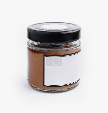 Clear glass jar with creamy peanut butter and a white blank label on a white background