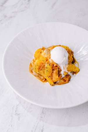 Elegant plate of creamy pasta topped with a citrus twist and a dollop of cream