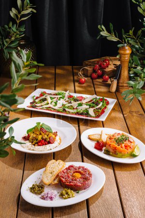 Elegante Präsentation von drei frischen Gourmet-Salaten auf rustikalem Holztisch