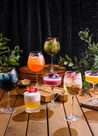 Collection of colorful, garnished cocktails displayed elegantly against a dark backdrop
