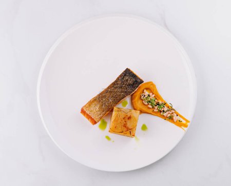 Plato de salmón bañado en gourmet con puré y guarnición sobre un fondo blanco minimalista