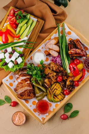 Vibrant platter of grilled meats, colorful vegetables, dips, and cheese, perfect for a summer feast