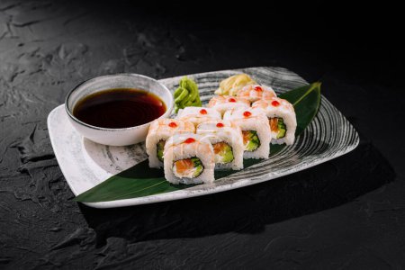 Eleganckie bułki sushi z krewetkami, awokado i ogórkiem serwowane z sosem sojowym na nowoczesnym talerzu