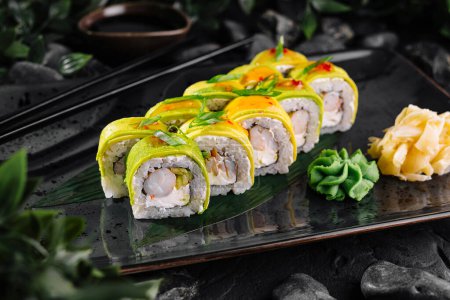 Vibrant array of mango-topped sushi garnished with avocado and served with wasabi and ginger