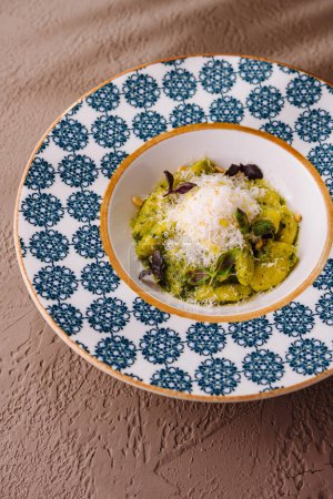 Exquisite serving of pesto pasta topped with grated parmesan, ready to enjoy