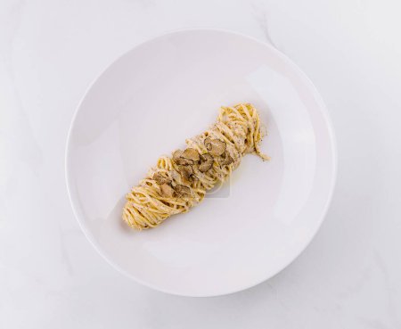 Exquisite serving of truffle pasta with shaved truffles on a sleek white plate