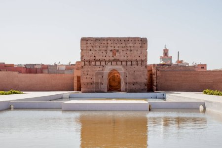 Badi Palace in Marrakesch mit Reflexion im Teich vor und Touristen im Hintergrund