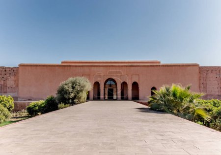 Badi Palace in Marrakesch mit Reflexion im Teich vor und Touristen im Hintergrund