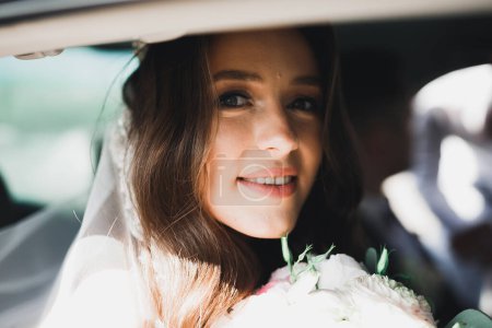 Photo for Beautiful bride sitting in the luxury retro car on wedding day. - Royalty Free Image