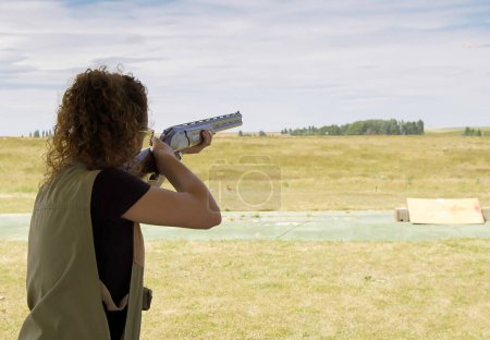 Foto de Mujer joven disparando con rifle en el campo. - Imagen libre de derechos