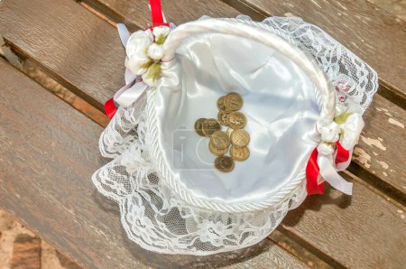 Arras, Münzen, die symbolisch für eine Hochzeitszeremonie verwendet werden, die in einen Korb gelegt werden, Pesetas. Alte goldblonde Münzen aus Spanien.