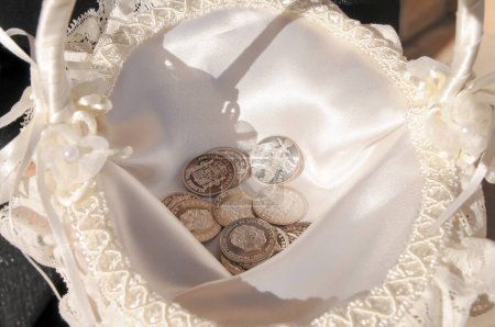 Arras, Münzen, die symbolisch für eine Hochzeitszeremonie verwendet werden, die in einem Korb platziert werden. Pesetas, alte spanische Silbermünzen.