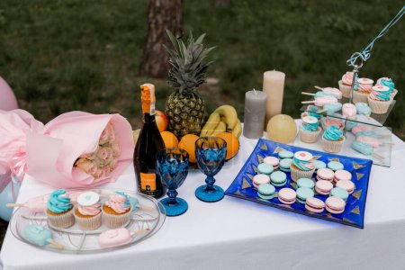 an Elegant baby shower table with desserts and balloons