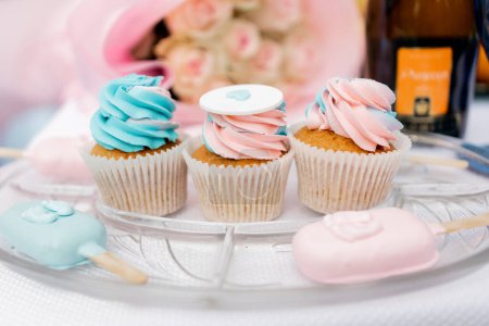 Pastellfarbene Cupcakes und Eis am Stiel zur Feier