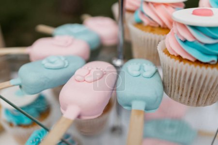 a Pastel cupcakes and ice cream and popsicles on display for a celebration.