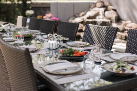 Téléchargez les photos : Une salade de jardin fraîche sur une table à manger extérieure élégamment dressée, parfaite pour des expériences culinaires en plein air - en image libre de droit