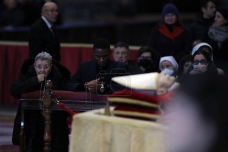 Téléchargez les photos : ROME, Italy - 04.02.2023: Old woman pray in the  Fourth and last day of exposure of the body of Pope Benedict XVI, Joseph Ratzinger at St. Peter's Basilica in the Vatican in Rome. - en image libre de droit