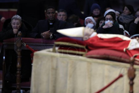 Foto de ROME, Italy - 04.02.2023: Old woman pray in the  Fourth and last day of exposure of the body of Pope Benedict XVI, Joseph Ratzinger at St. Peter's Basilica in the Vatican in Rome. - Imagen libre de derechos