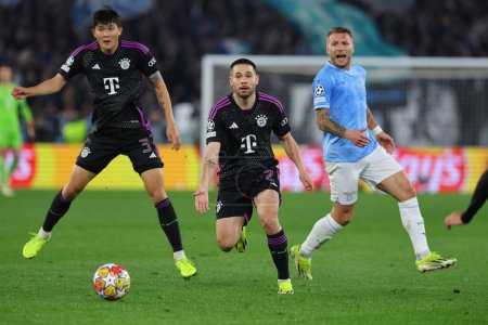 Photo for Rome, Italy 14.2.2024: Minjae Kim of Bayern Munchen, Raphael Guerreiro of Bayern Munchen, Ciro Immobile of Lazio in action during the Uefa Champions League 2023-2024, round of 16 football match  SS Lazio vs FC Bayern Mucnhen at Olympic Stadium in Rom - Royalty Free Image