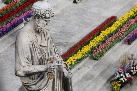 Photo for Vatican City, Italy 31.03.2024:  Statue of Saint Peter with flowers as a background., Pope Francis presides over the rite of Easter mass in the churchyard of St. Peter's Square for Easter Holy Week at the Vatican City in Rome - Royalty Free Image