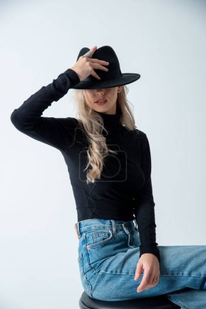 Téléchargez les photos : Belle femme blonde posant avec chapeau en studio - en image libre de droit