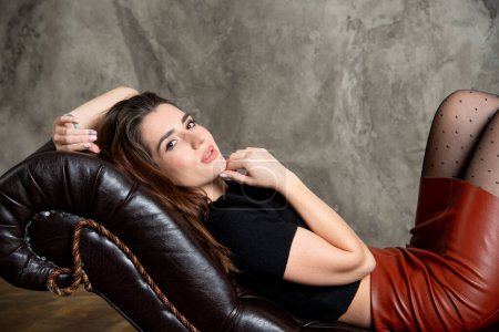 Foto de Atractiva chica morena sexy posando en el sofá - Imagen libre de derechos