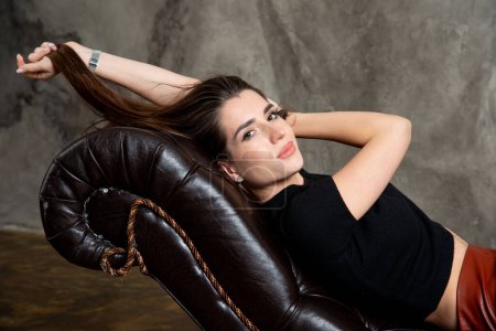 Téléchargez les photos : Attrayant sexy brunette fille posant sur canapé - en image libre de droit