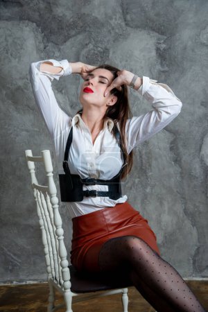 Téléchargez les photos : Belle femme sexy posant en studio contre le mur gris - en image libre de droit