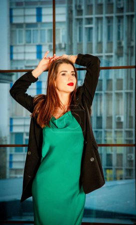 Photo for Young beautiful woman in green dress and black jacket - Royalty Free Image