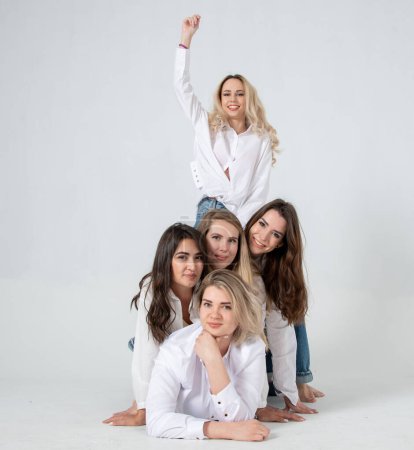 Téléchargez les photos : Young attractive women in white shirts and jeans posing in the studio - en image libre de droit