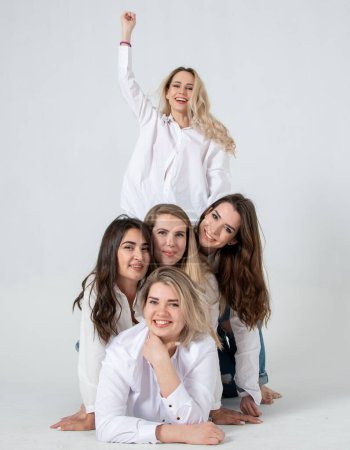 Photo for Young attractive women in white shirts and jeans posing in the studio - Royalty Free Image