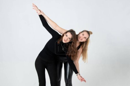 Photo for Two young women in black clothes posing on white background - Royalty Free Image