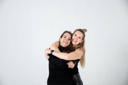 Téléchargez les photos : Two young women in black clothes posing on white background - en image libre de droit